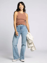 Woman wearing the Edlin Basic Tank in striped style with jeans for casual look