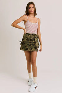 Woman wearing a striped tank top and camouflage skirt showcasing shoulder tie boho chic clothing