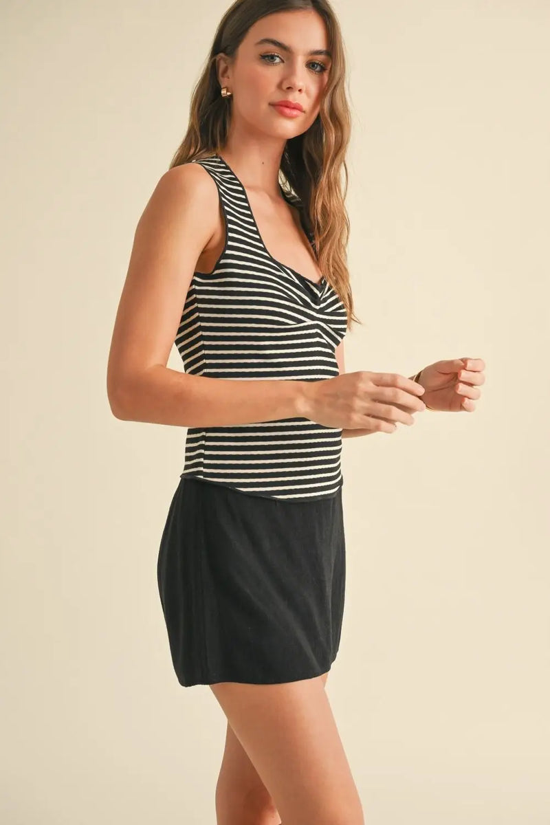 Woman in striped tank top and black skirt showcasing women’s boho chic clothing at Shop Daisy