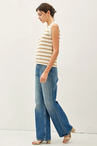 Woman wearing a chunky knit striped sweater tank and wide-leg jeans, showcasing stylish casual wear