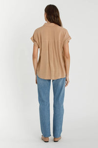 Women wearing a tan shirt and blue jeans in SOLID SHORT SLEEVE BUTTON DOWN SHIRT for women’s boho chic clothing at Shop Daisy