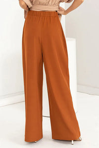 Woman in a tan top showcasing high waist wide-leg pants, perfect for stylish outfits