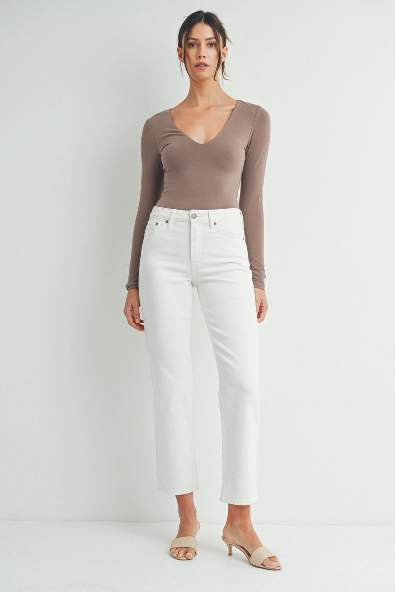 Woman in taupe long-sleeved top and white cropped pants, embodying a boho free spirit style