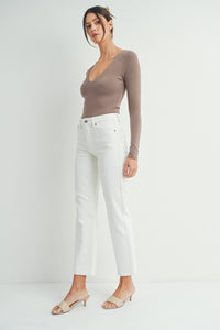 Woman in taupe long-sleeved top and white pants for a boho free spirit look