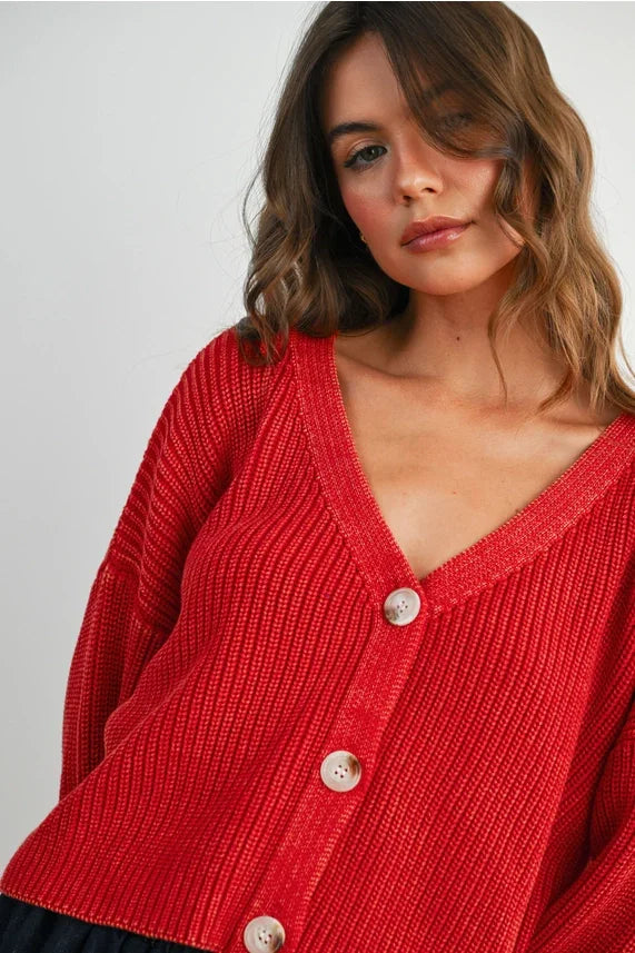 Woman wearing vibrant red V neck buttoned ribbed long sleeve cardigan