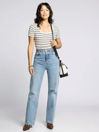 Woman wearing supply katara tee with high-waisted jeans and brown flats