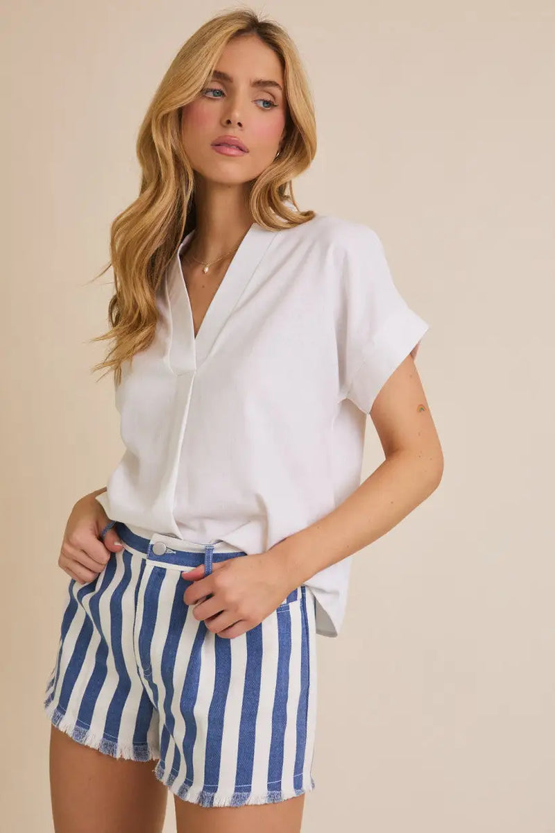 Woman wearing white blouse with short sleeve flare and flare hem detail