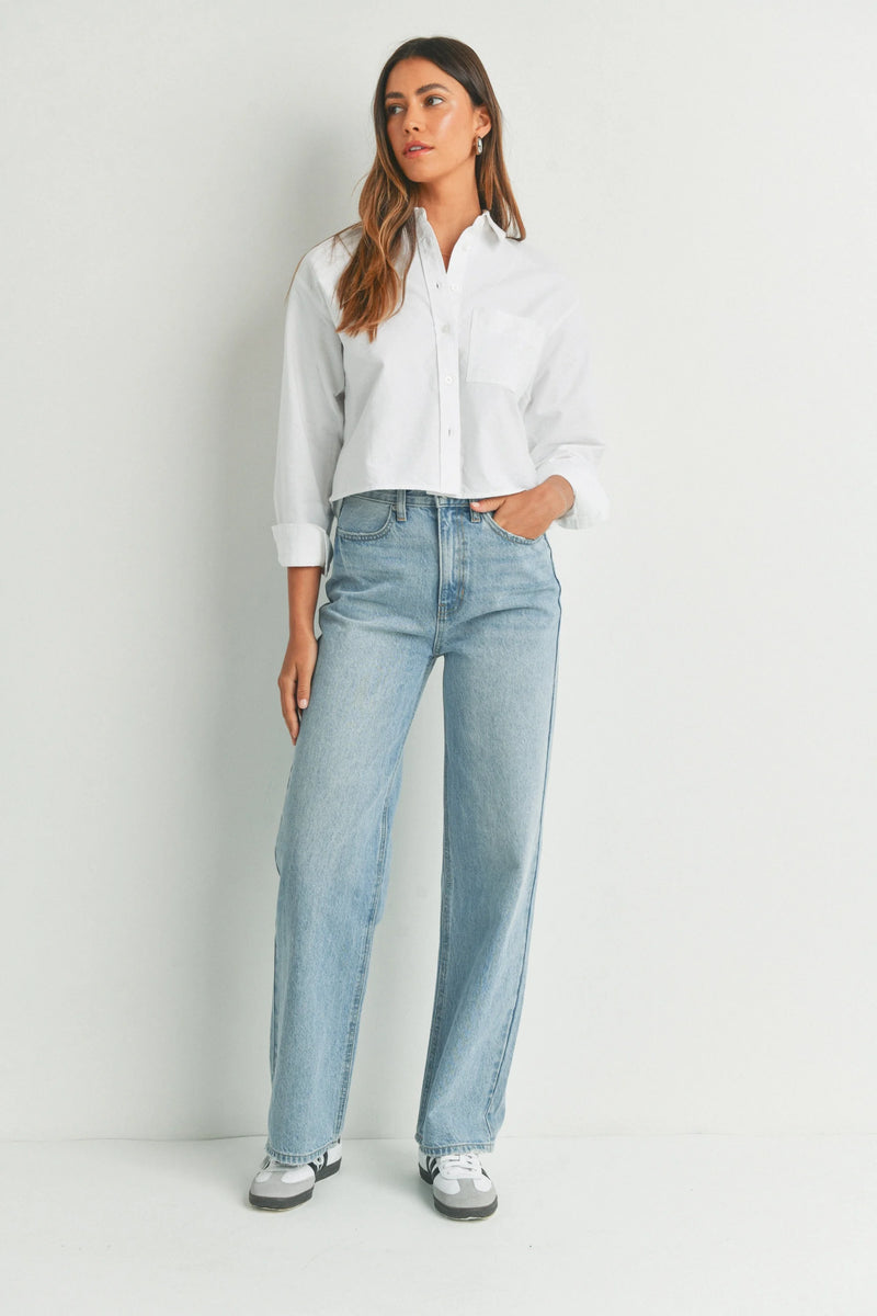 Woman in white button-up and light blue high waisted skater jean outfit