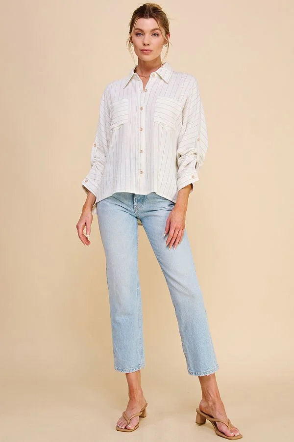 Woman in a white pinstripe dolman button front shirt and light blue jeans