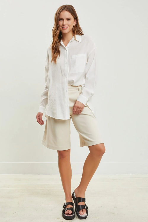 Woman in white shirt and beige wide leg half pants showcasing PLEATED WIDE LEG style