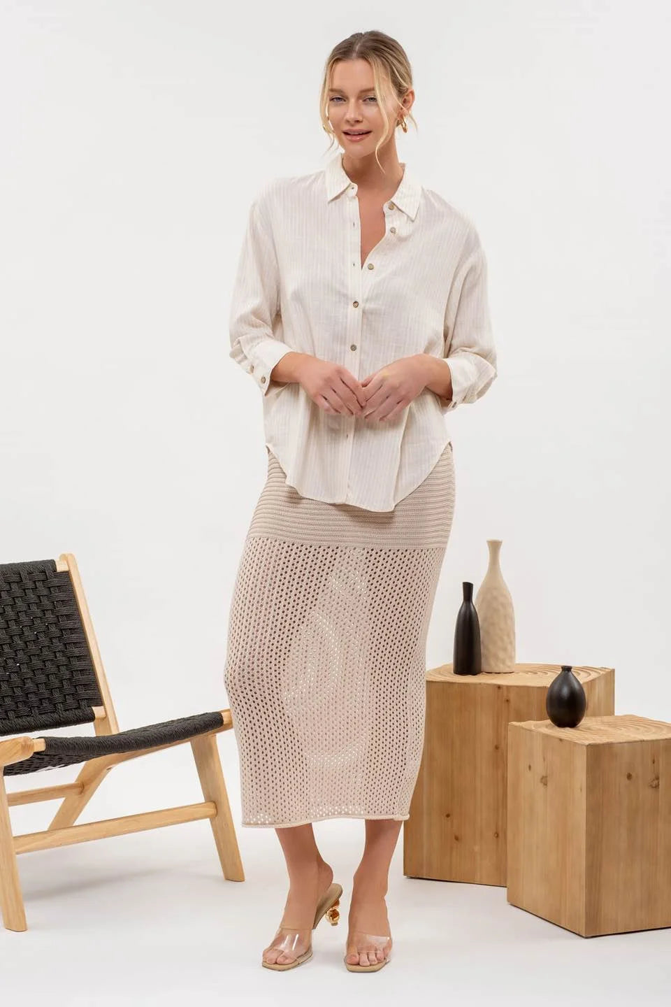 Woman in a white stripe button down shirt and knitted skirt showing casual style