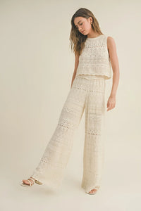 Woman in white crochet pattern top and matching crochet pattern pants for a stylish look