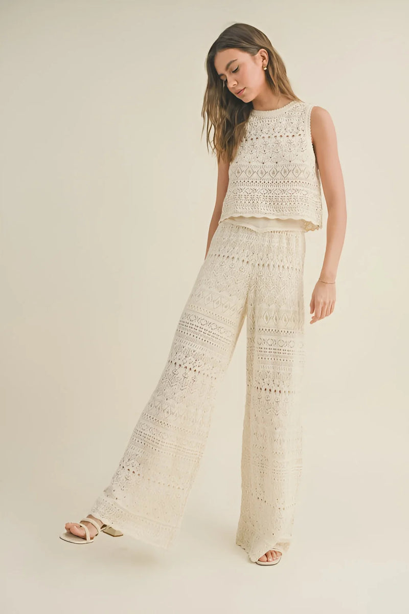 Woman in white crochet pattern top and matching crochet pattern pants for a stylish look