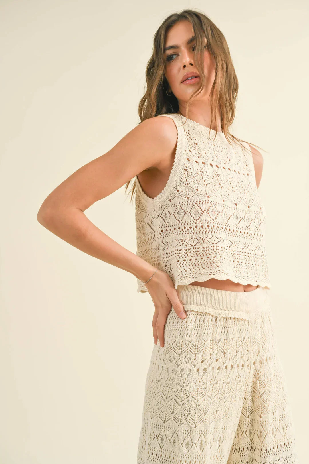 Woman in a white match crochet pattern button back top and matching skirt