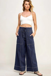 Woman in a white crop top and navy blue cotton twill wide leg pants