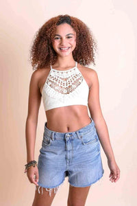 Woman in white crop top and denim shorts showcasing Crochet Lace High Neck Bralette