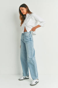 Woman in a white crop top and light blue baggy jeans, showcasing High Waisted Skater Jean