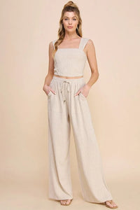 Woman in pinstriped soft linen cropped bustier tank and wide-leg pants ensemble