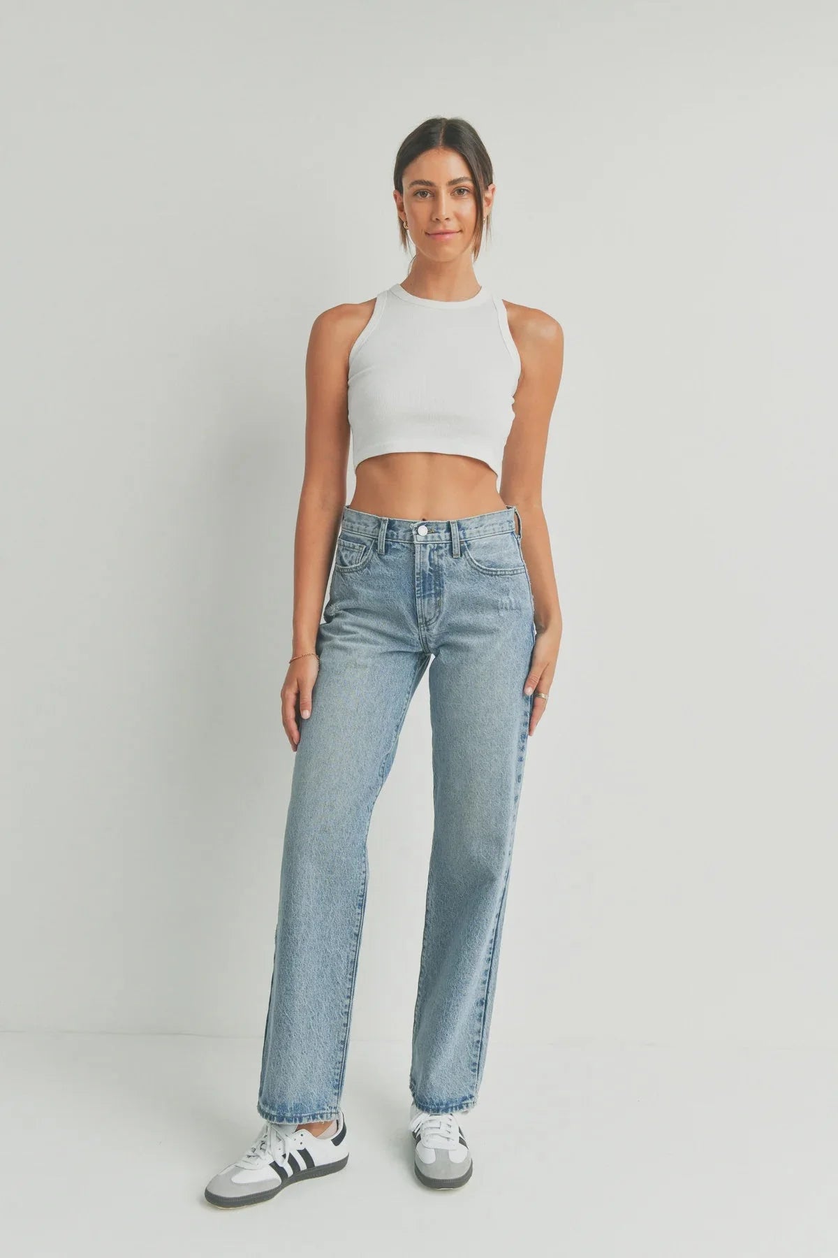 Woman in a white crop top and blue jeans, embodying boho free spirit style