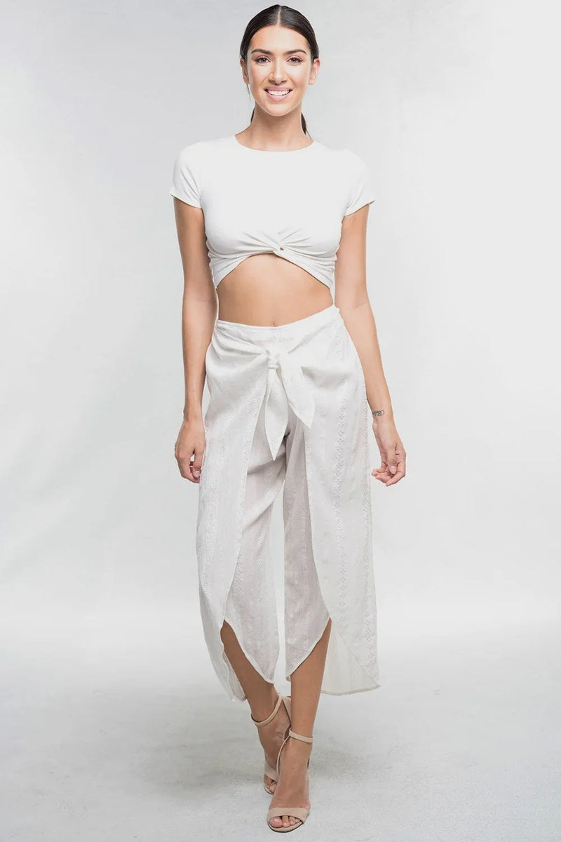 Woman in a white crop top and flowy wrapped skirt, embodying boho free spirit style