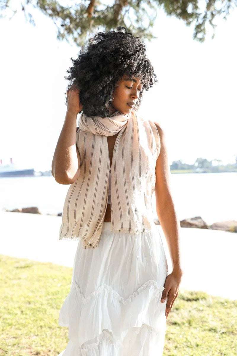 Woman in a white dress showcasing a Pencil Stripe Double Weave Scarf