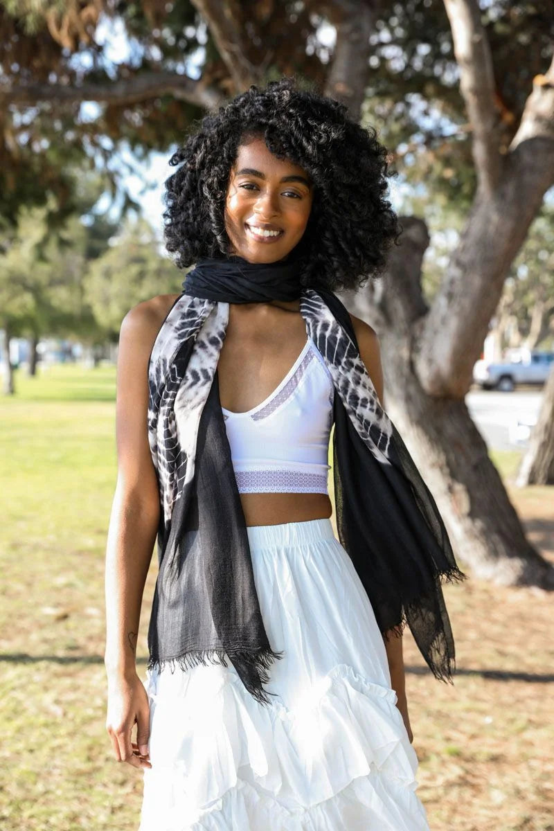 Woman in a white dress showcasing a Tie Dye Lightweight Scarf with a black scarf