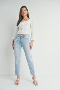 Woman in a white top and jeans showcasing Slim Straight with Distress Denim style