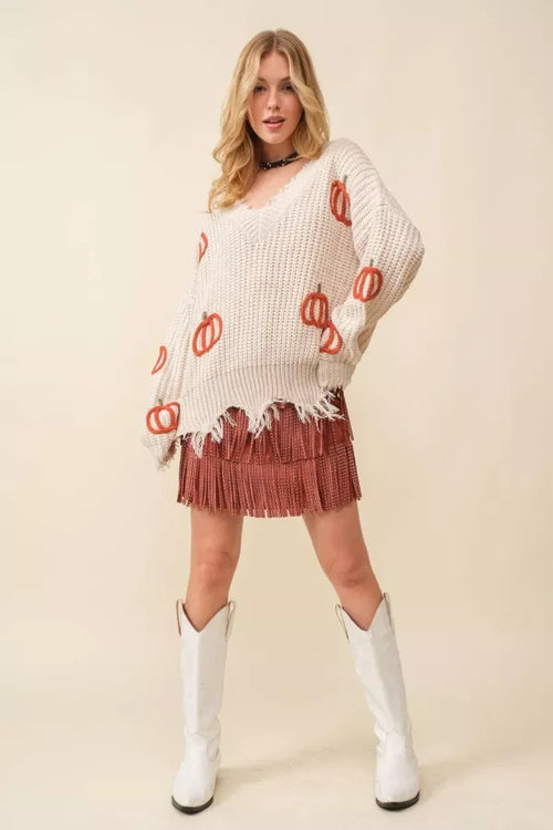 Woman in white knit sweater and fringed skirt, perfect for women’s boho chic clothing