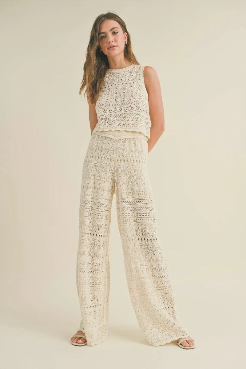 Woman in white lace top and wide-leg pants from the Match Crochet Pattern collection