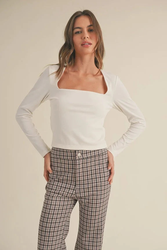 Woman in a white long-sleeved top and plaid pants from Shop Daisy women’s boho clothes