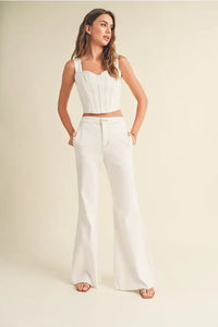 Woman wearing white top and pants from the Stretched Cotton Denim Look Pants collection