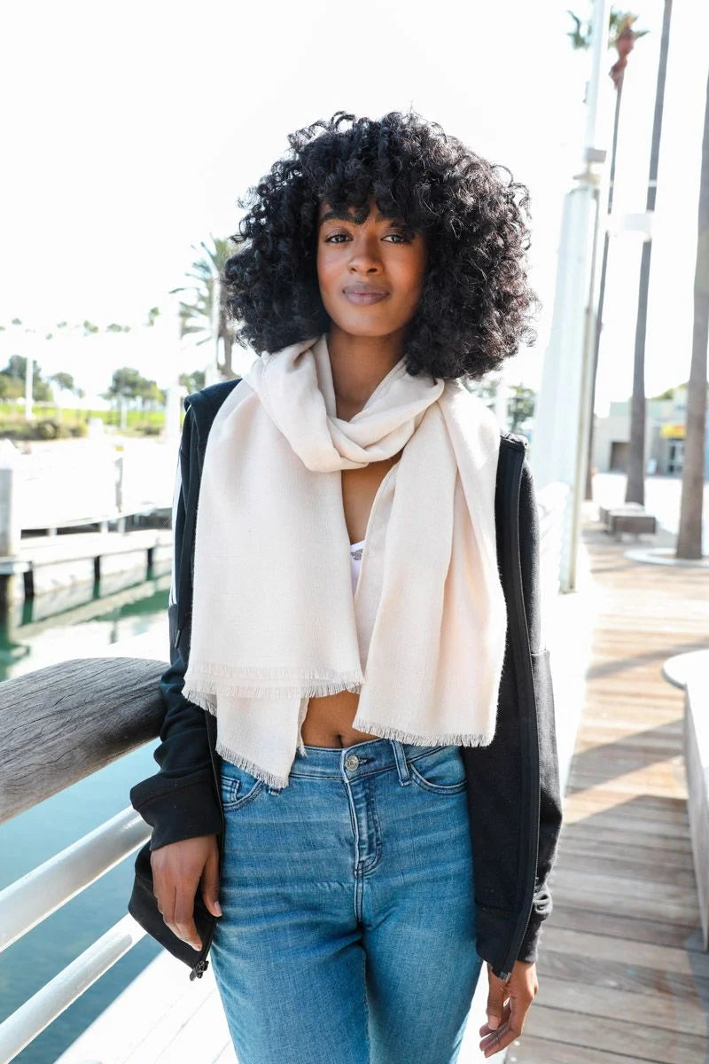 Woman in a white scarf and jeans showcasing a Soft Woven Frayed Edge Scarf