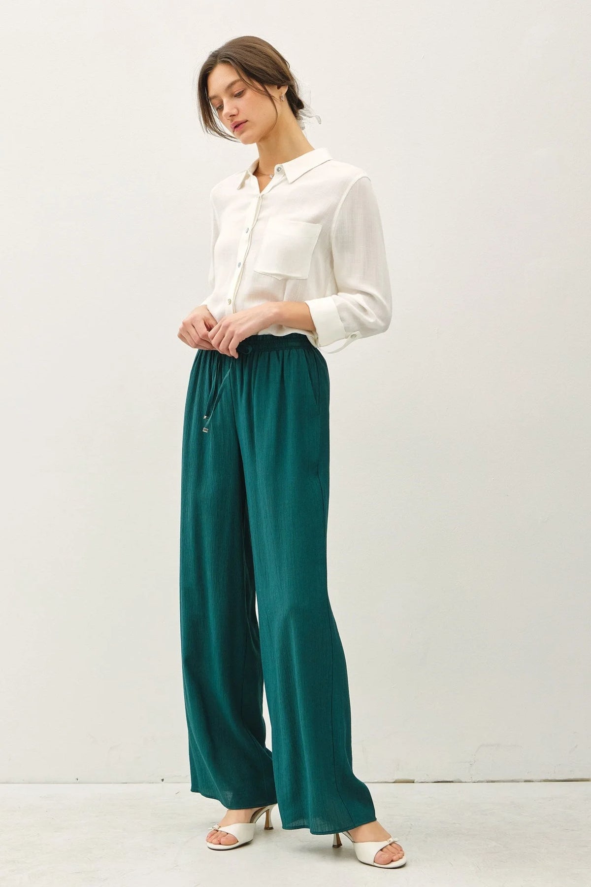Woman in white shirt and green crinkle wide leg pants with elastic drawstring waist for boho chic style