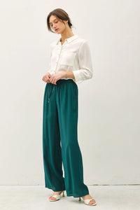 Woman in white shirt and green crinkle wide leg pants with elastic drawstring waist for boho chic style