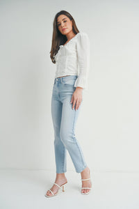 A woman in a white shirt and jeans showcasing Slim Straight Distress Denim style