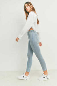 Woman in a white shirt and jeans wearing THE HR Essential Skinny Denim outfit