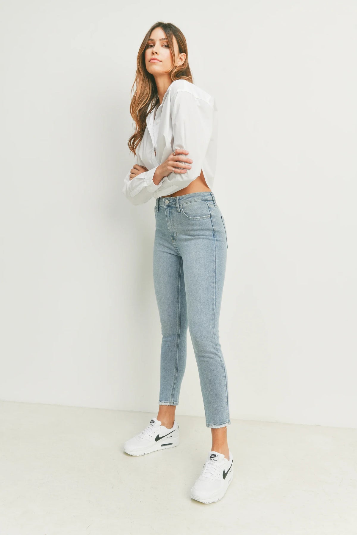 Woman in a white shirt and jeans showcasing THE HR Essential Skinny Denim