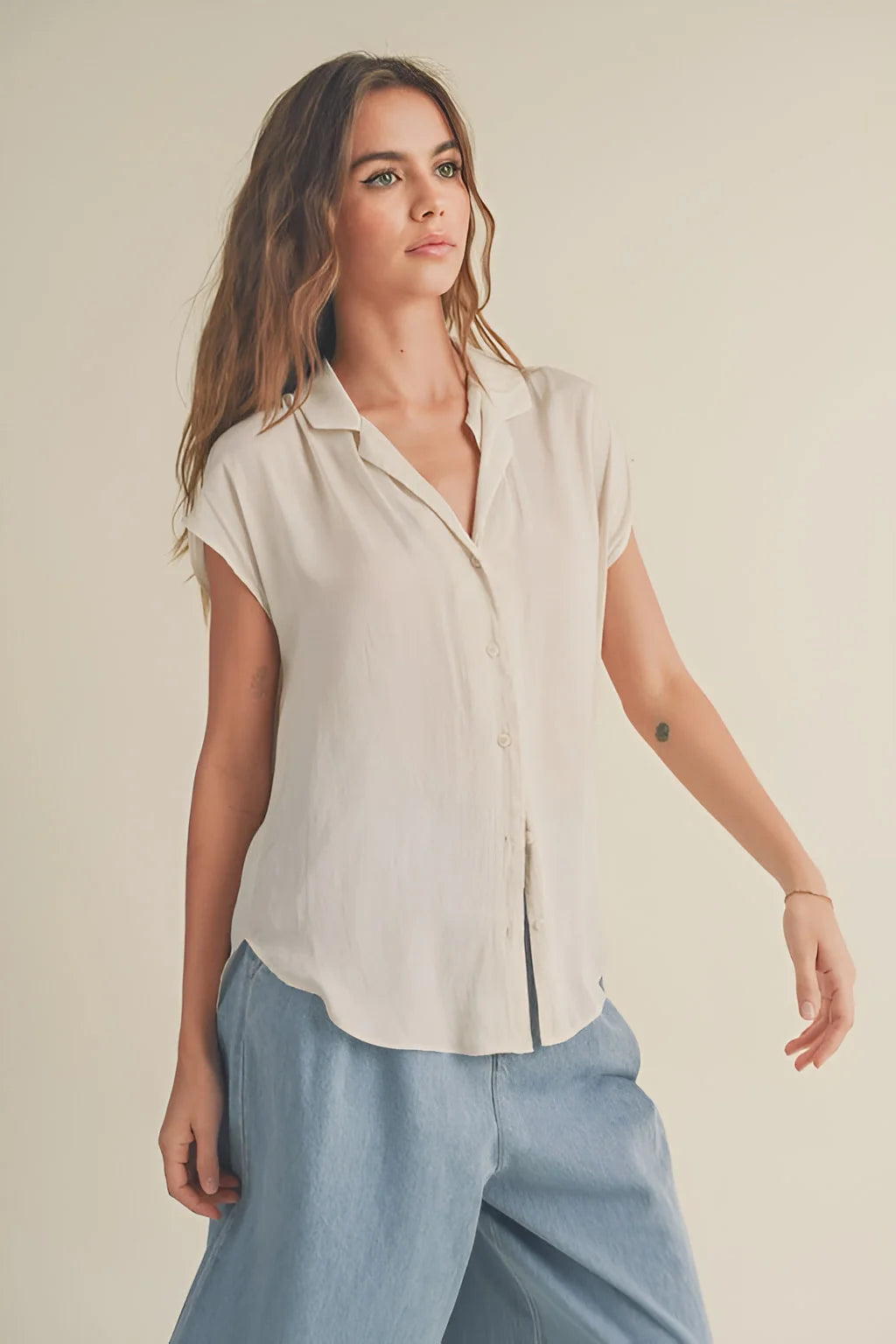 Woman in a white short-sleeved button-up shirt from BUTTON DOWN CAP SLEEVE SHIRTS