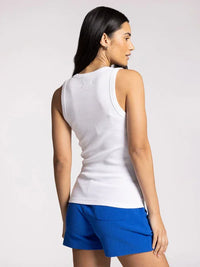 Woman in white sleeveless top and blue shorts showcasing the Edlin Basic Tank