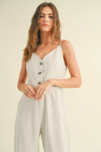 Woman in a white sleeveless jumpsuit showcasing women’s boho chic clothing from Shop Daisy