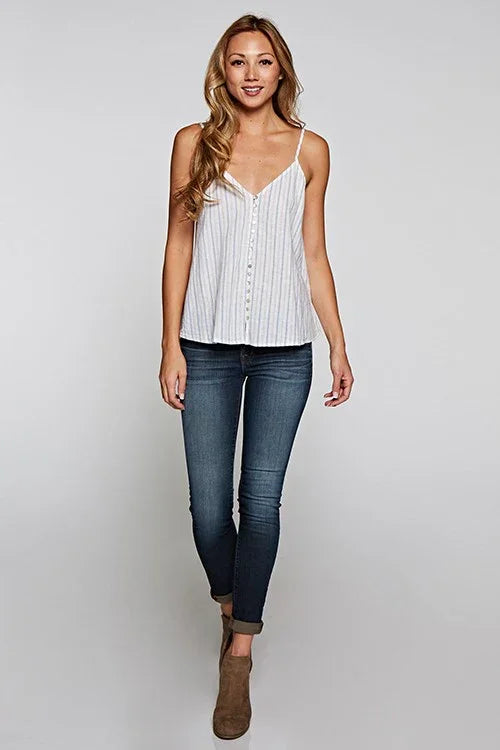 Woman modeling white striped camisole with dark wash skinny jeans and brown ankle boots for women’s boho chic clothing at Shop Daisy