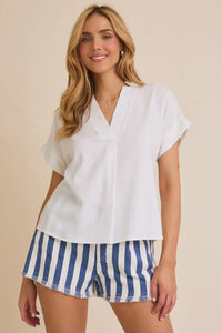 Woman wearing a white top with short sleeve flare and flare hem details for style