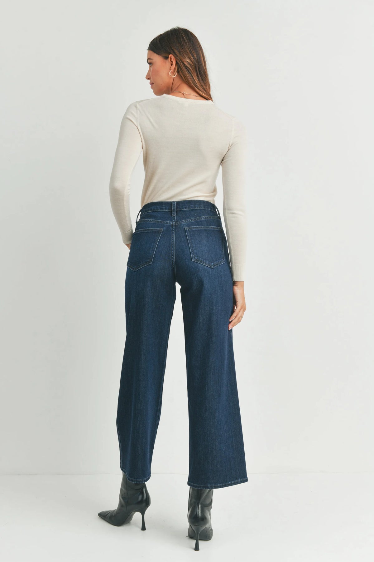 Woman in a white sweater showcasing Seamed Utility Straight Jeans for stylish comfort