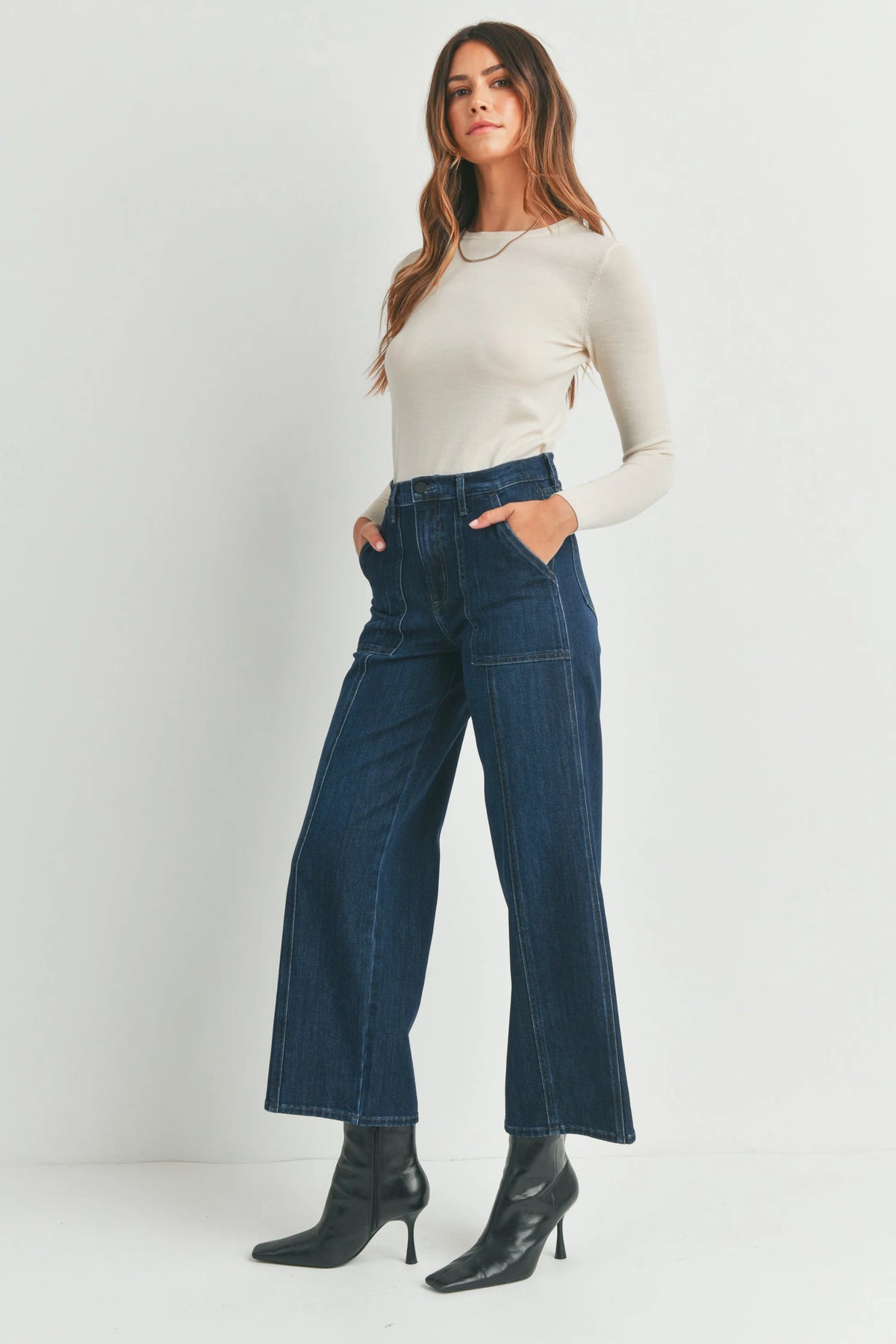 Woman in a white sweater showcasing Seamed Utility Straight Jeans in a stylish setting