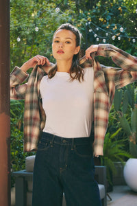 Woman wearing a classic cotton plaid shirt with a white t-shirt and dark jeans