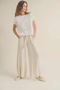 Woman in white t-shirt and beige cotton linen smocked waist pants