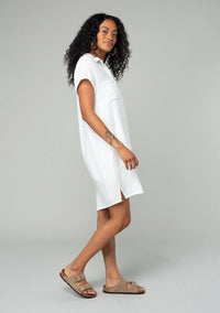 Woman in a flowy white t-shirt dress and sandals, embodying boho free spirit style