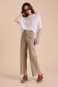 Woman wearing tan straight wide leg denim pants and a white top showcasing style
