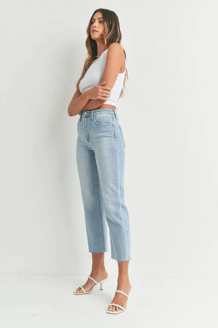 Woman in classic straight denim showcasing a stylish white tank top and jeans