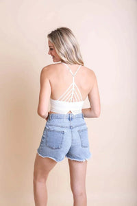 Back view of a woman in a white tank top and denim shorts showcasing a High Neck Crochet Lace Trim Bralette